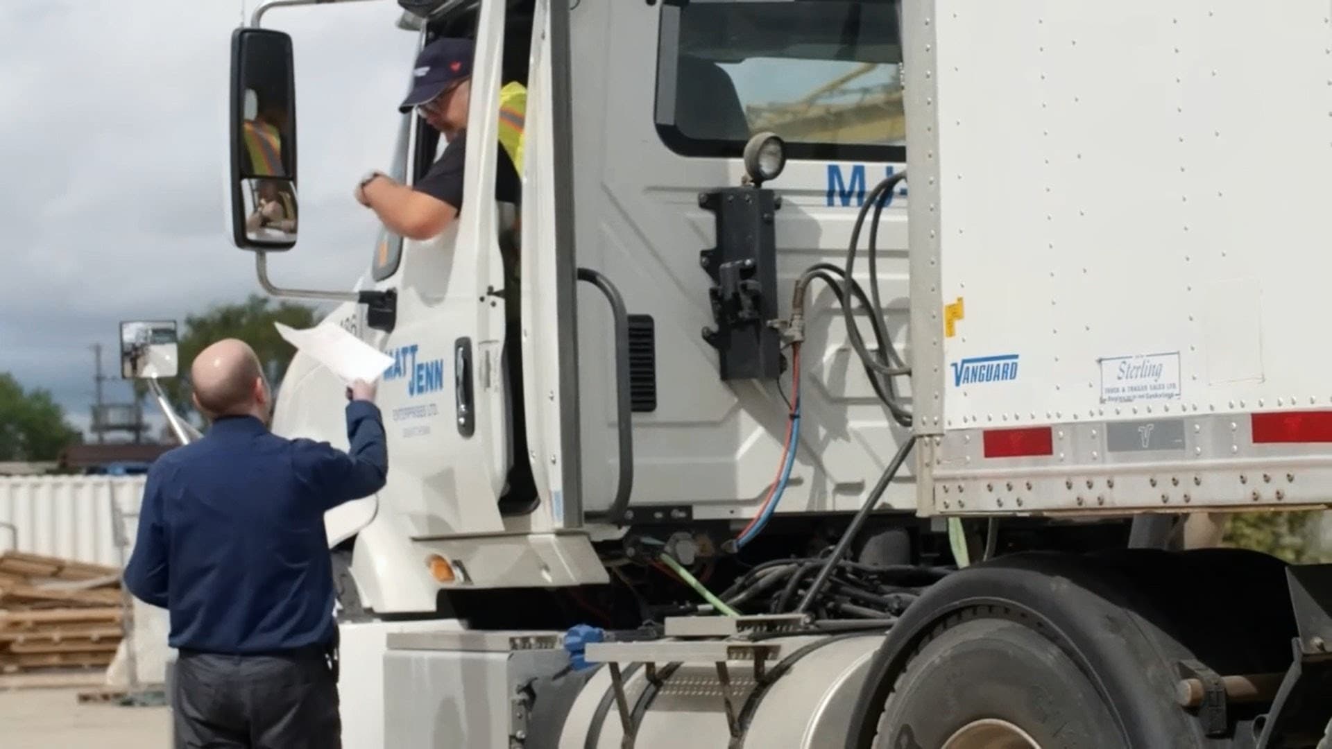 A National Cartage driver and dispatcher going over paperwork at the cab