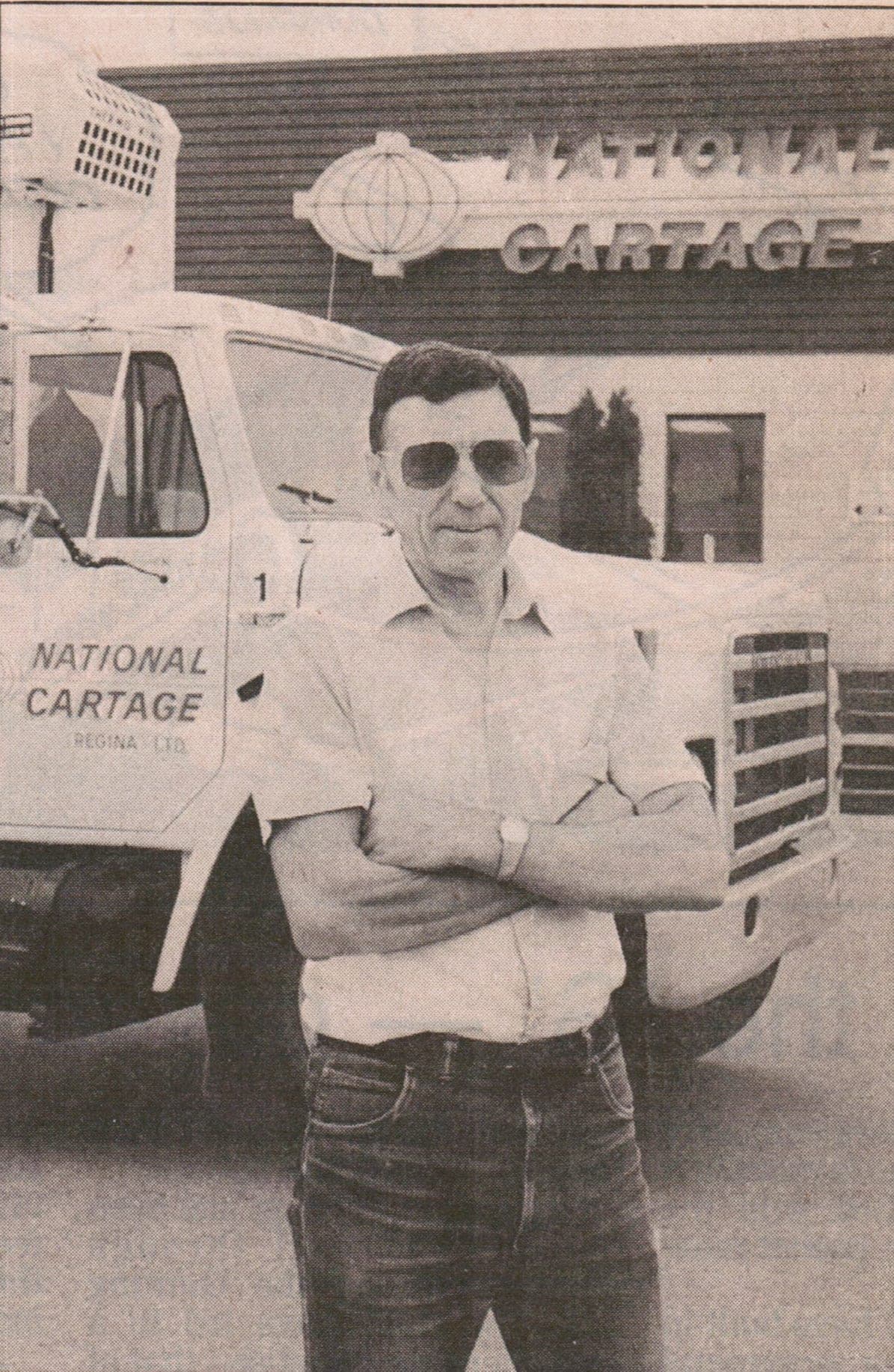 Al Yaehne standing in front of National Cartage truck number one outside the Regina office, from a 1989 newspaper